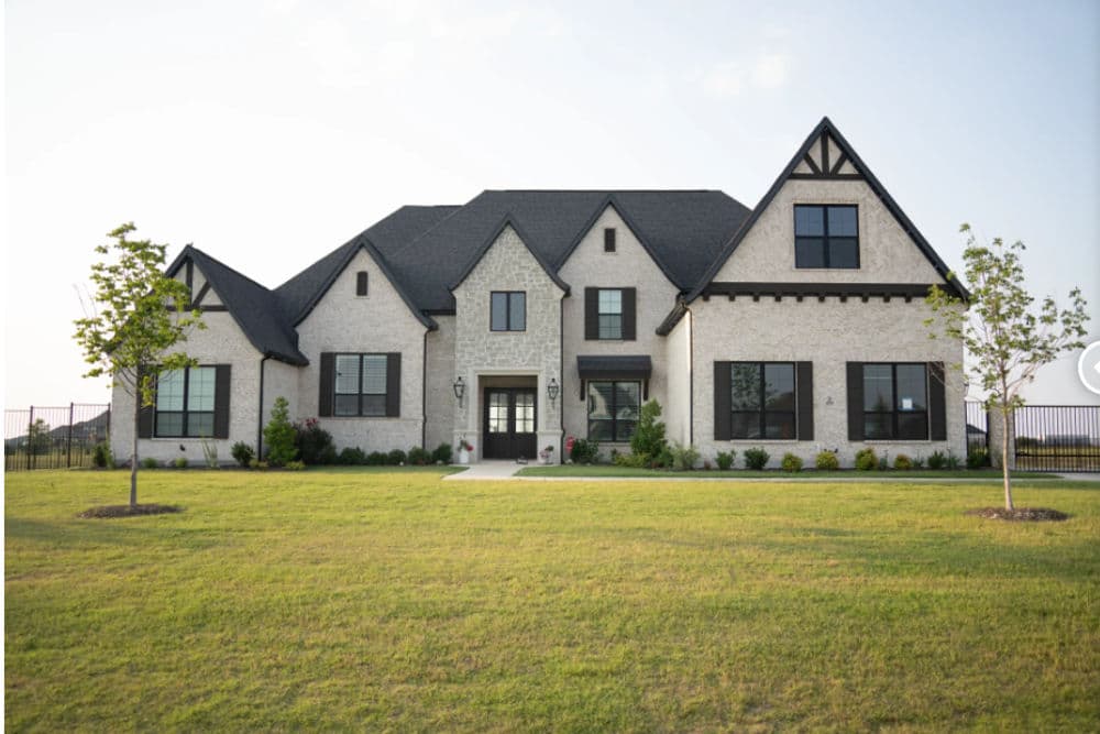 Elegant modern house exterior at dusk with decorative lighting and landscaped yard.
